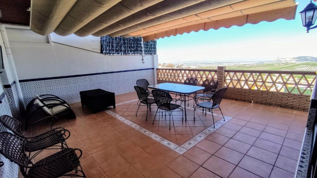 a patio with a table and chairs on a balcony at Casas Medina Güevéjar in Güevéjar