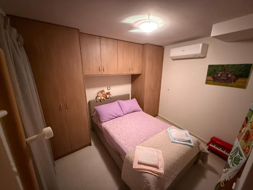 a small bedroom with a bed and a cabinet at Villa GIANNAKOS MINOAN HERSONISSOS in Kastéllion