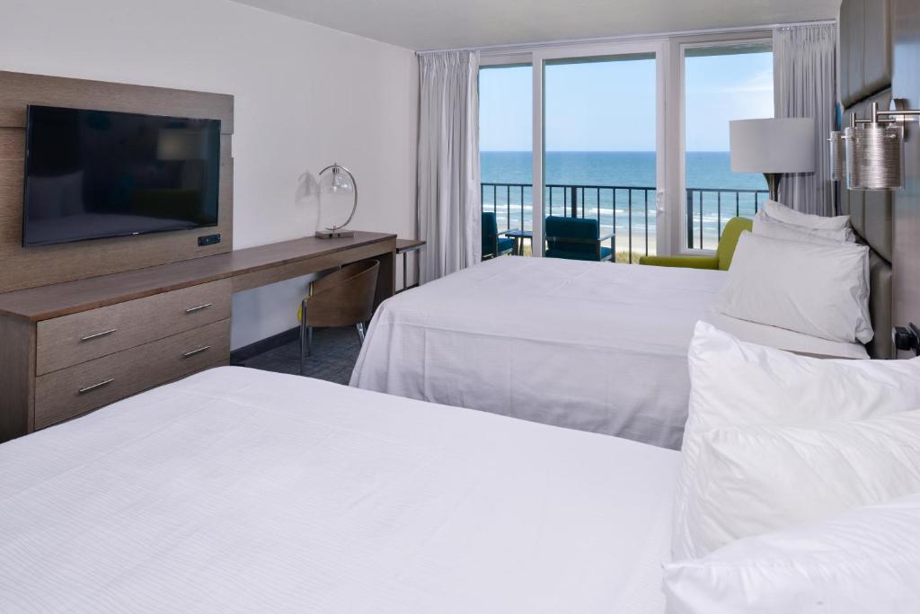 a hotel room with two beds and a television at Cabana Shores Hotel in Myrtle Beach