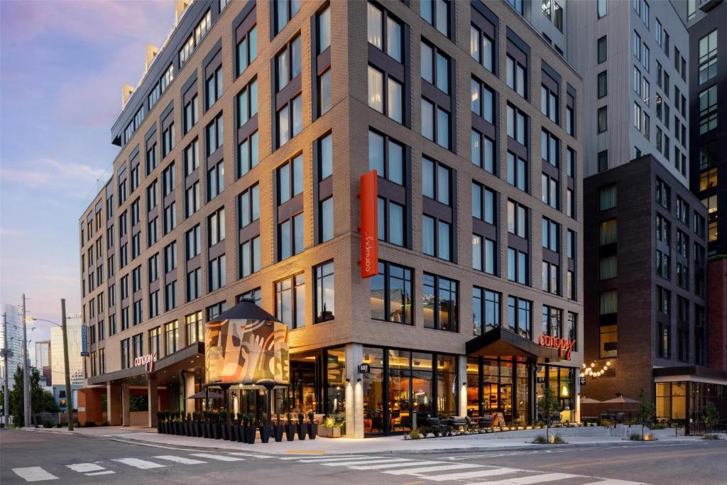 een groot gebouw in een stadsstraat met een winkel bij Canopy By Hilton Nashville Downtown The Gulch in Nashville