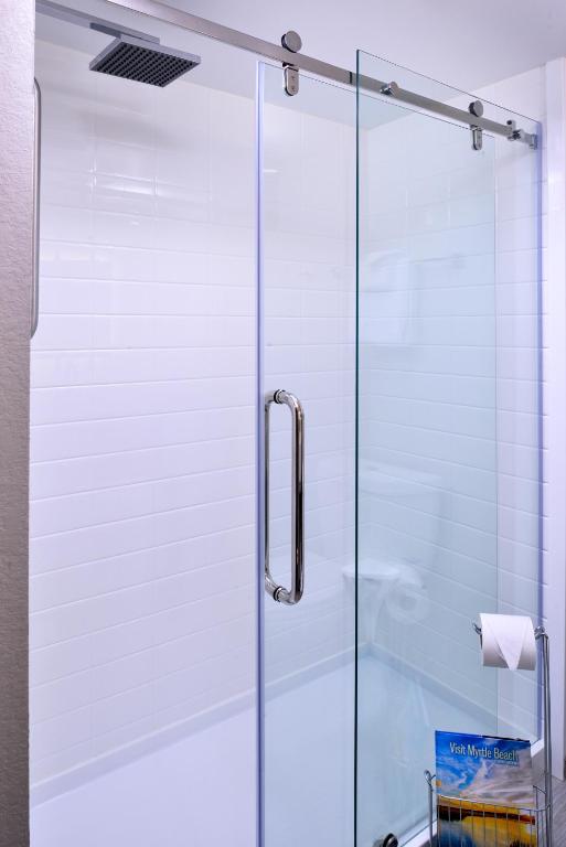 a shower with a glass door in a bathroom at Cabana Shores Hotel in Myrtle Beach