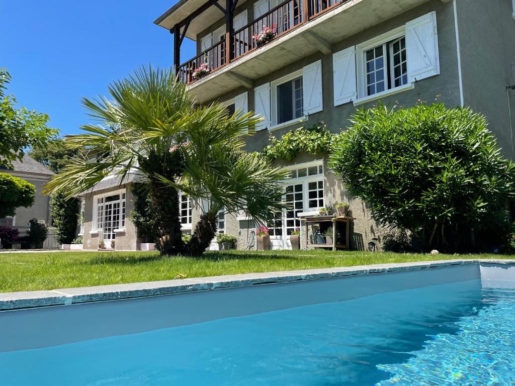 a house with a swimming pool in front of a building at Les Hortensias in Espoey