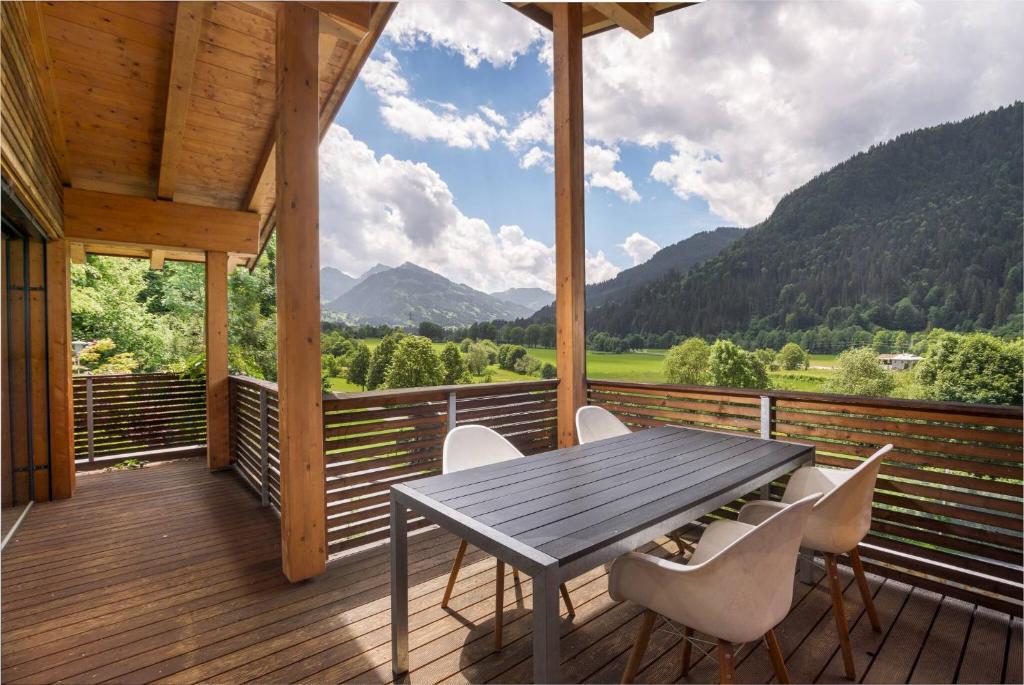 a wooden deck with a table and chairs on it at Ski & Golf Auszeit Apartment by Alpine Host Helpers in Kitzbühel