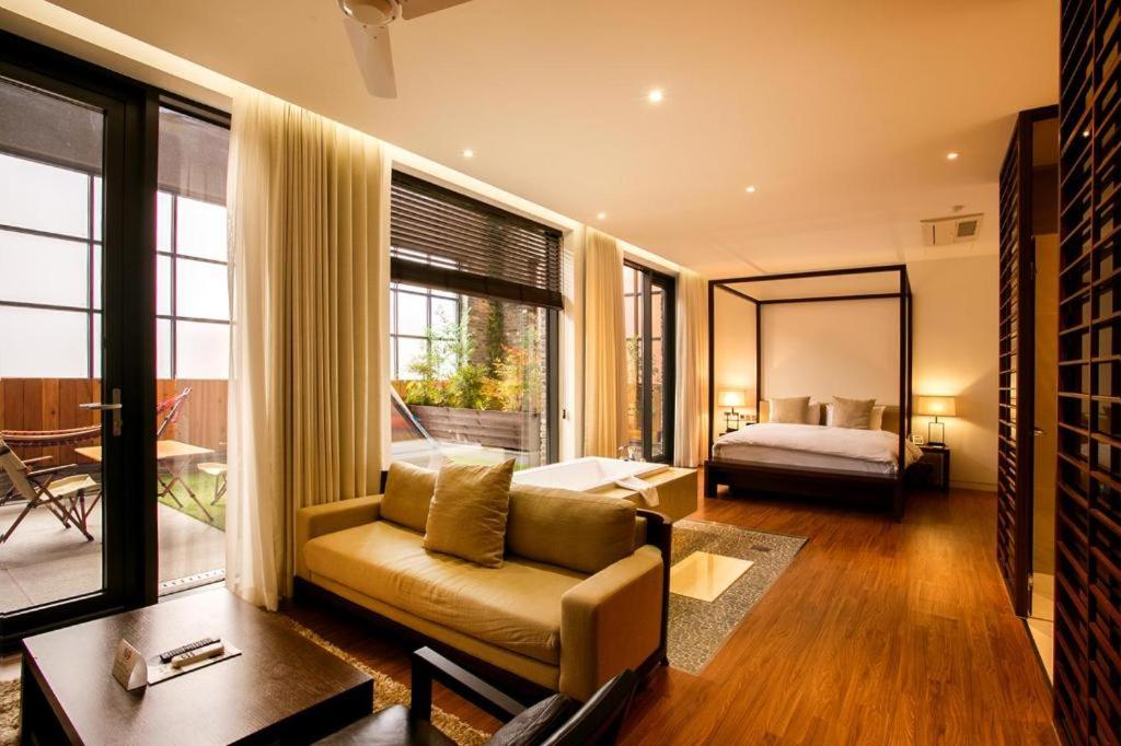 a living room with a couch and a bed and a mirror at The Classic by Hotelone in Jeonju