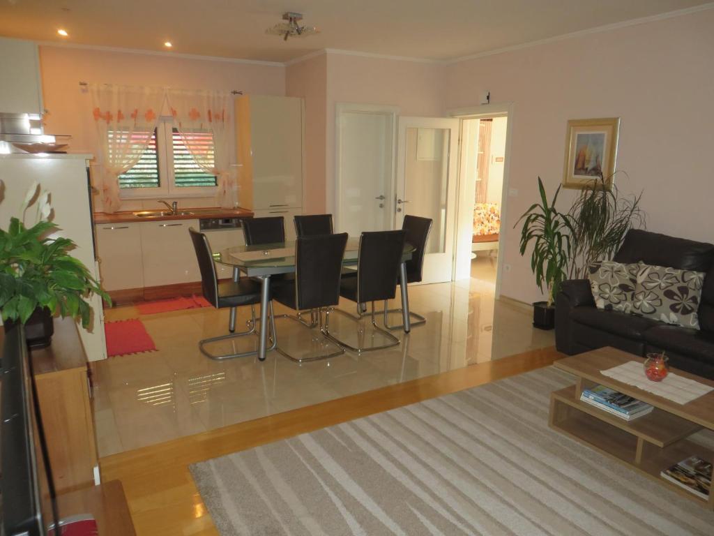 a living room and kitchen with a table and chairs at Apartment Simaris - spacious with terrace and sea view in Šibenik