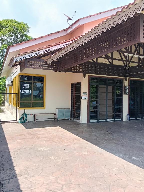 a building with awning and a bench on a patio at Azzahra Homestay in Permatang Pauh