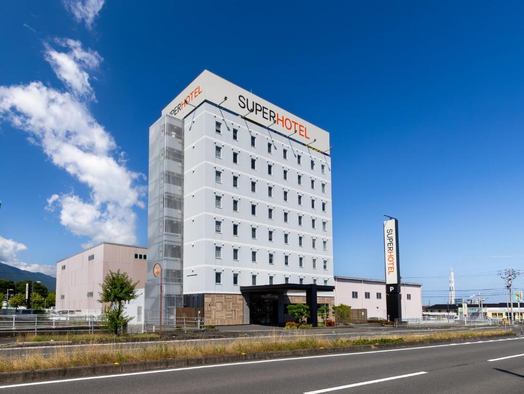 四国中央市Super Hotel Shikoku-chuo的白色的建筑,上面有超级酒店标志