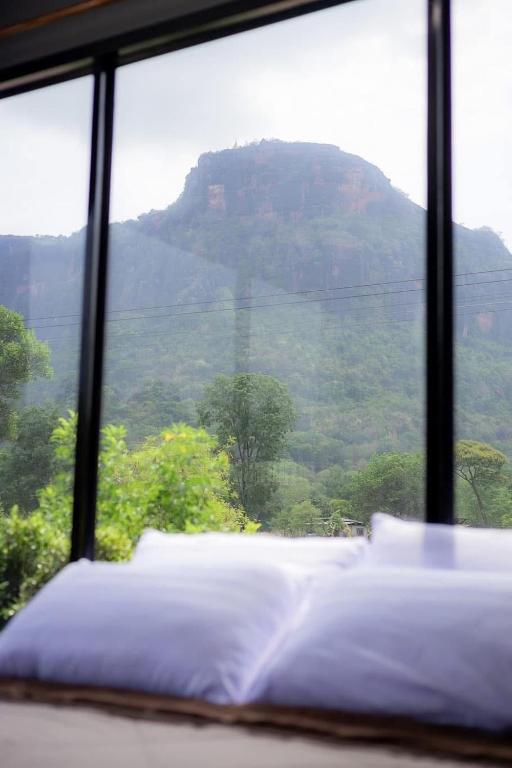 a bed in a room with a view of a mountain at Npuhomestay Naka Cave in Bung Khong Long