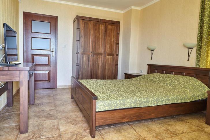 a bedroom with a bed and a wooden door at Villa Katalina in Varna City