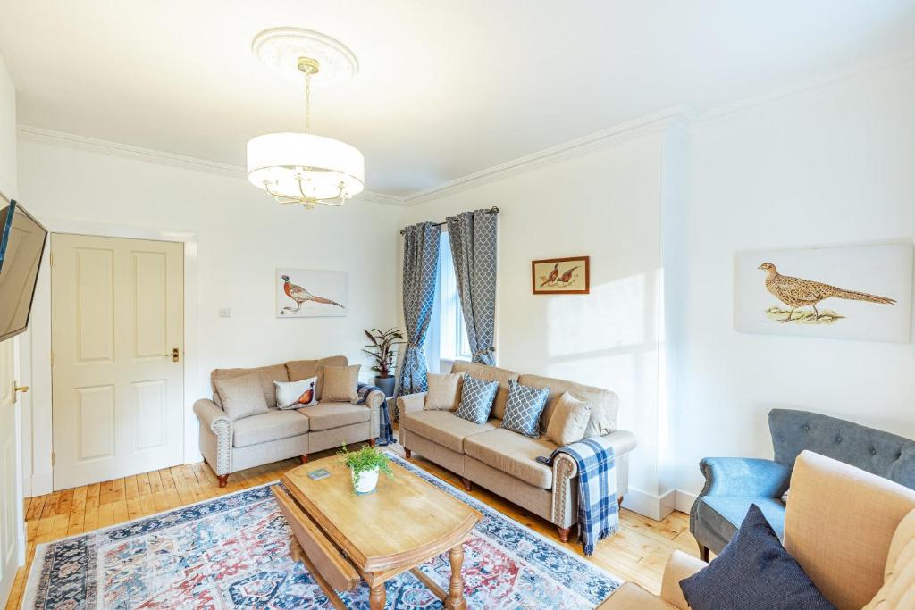 a living room with a couch and a table at Penninghame Estate - West Lodge in Challoch