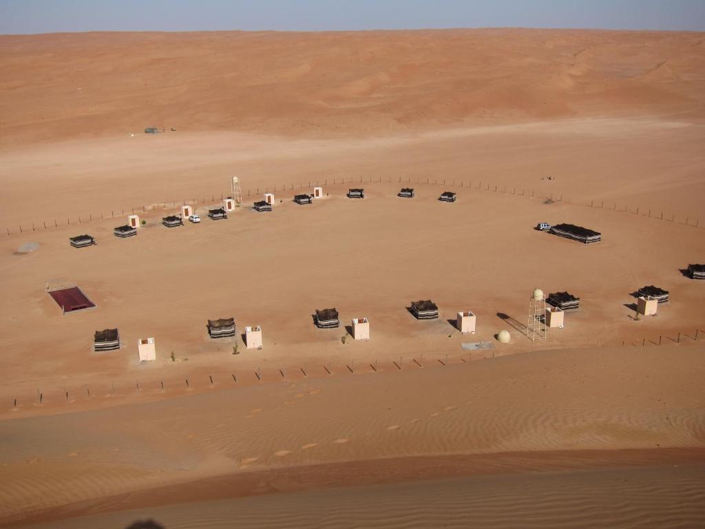 an aerial view of a desert with cars parked at Desert Retreat Camp in Al Wāşil