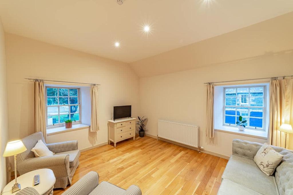 a living room with a couch and a tv at Penninghame Estate - Bruce Apartment in Challoch