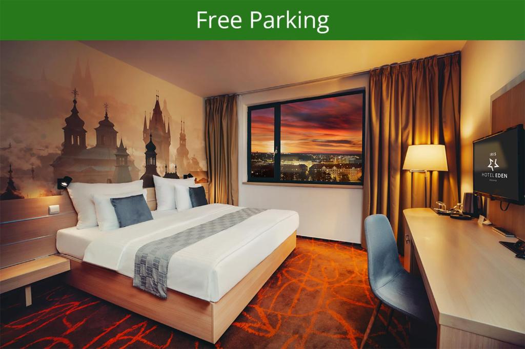 布拉格Iris Hotel Eden - Czech Leading Hotels的一间带床、书桌和窗户的酒店房间