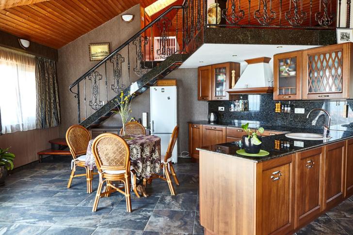 una cocina con mesa y sillas y una escalera en Villa Katalina en Varna