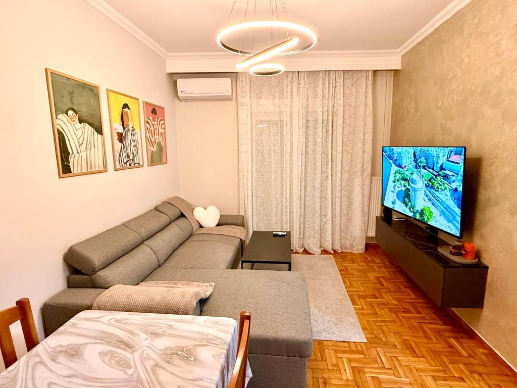 a living room with a couch and a flat screen tv at Cozy 2 Bedroom Condo by Waterfront & Metro in Thessaloniki