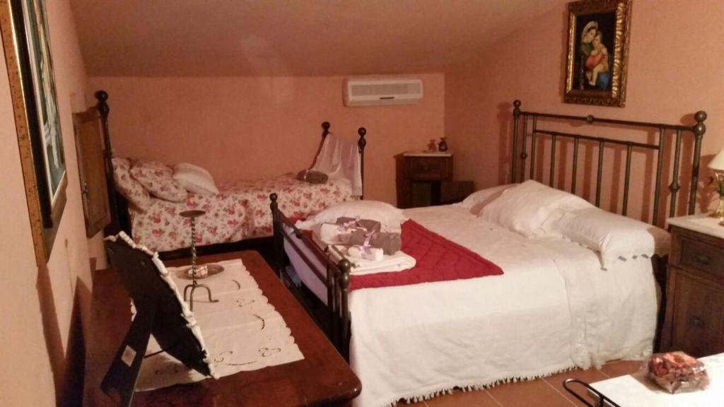 ラテリーナにあるIl Ghianderino Casa Vacanzeのベッドルーム1室(ベッド2台、テーブル、デスク付)
