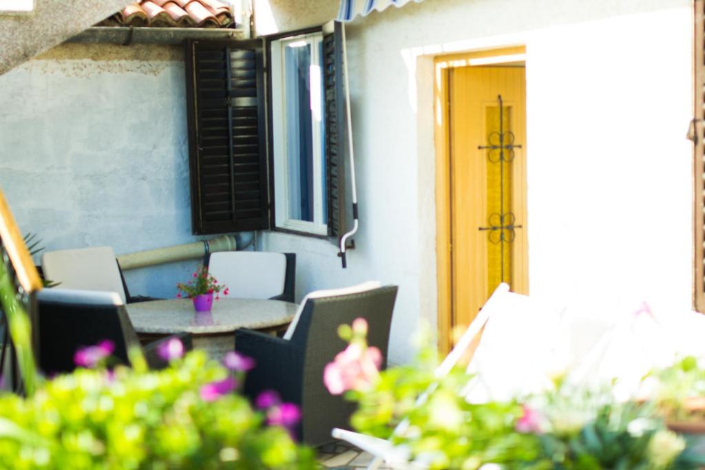 a patio with a table and chairs and a yellow door at Apartment Magdic in Brzac
