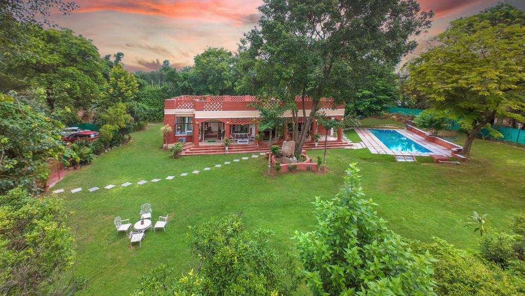 an aerial view of a house with a swimming pool at Hostie Tranquil Greens farmhouse near Golf course road Gurgaon in Gurgaon