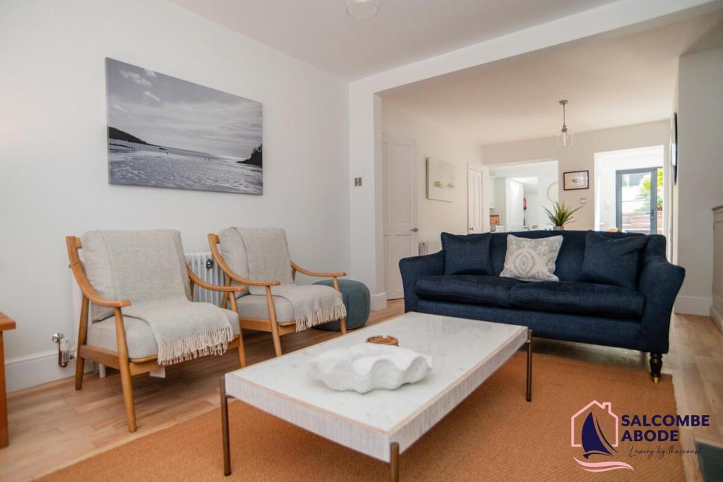 a living room with a blue couch and two chairs at Stylish Coastal 3 Bed Haven - Close to town in Salcombe