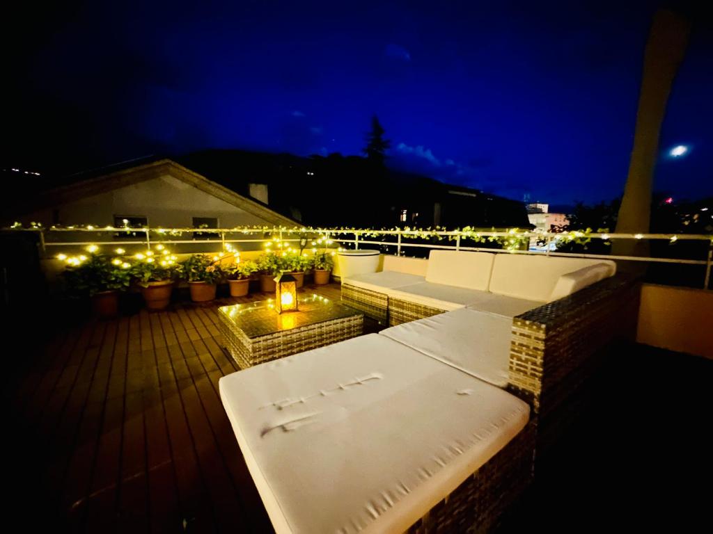 a rooftop deck with benches and lights at night at La Petite Maline friends & family in Sierre