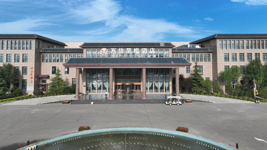 un gran edificio con un gran patio frente a él en 邢台鹊山水世界万信至格酒店, en Xingtai
