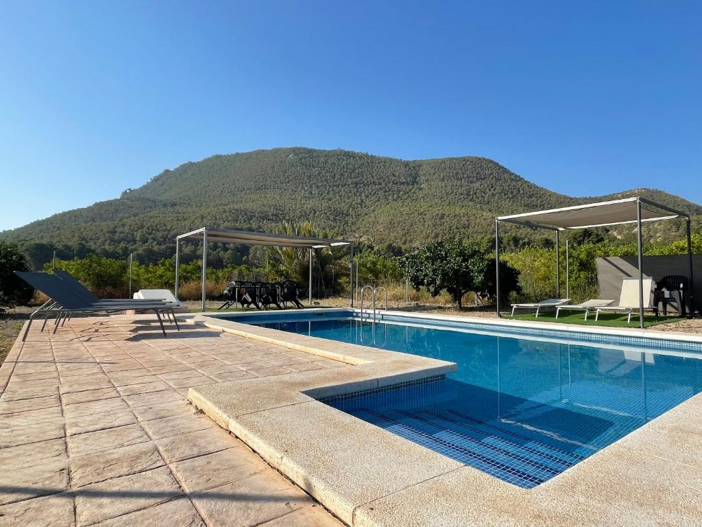 a swimming pool with a mountain in the background at Finca el Campillo Casas Joselito y Nene Pili in Blanca