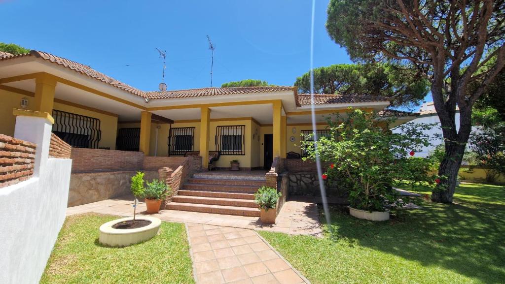 a house with stairs and plants in the yard at La Barrosa - Chalet La Morenita in Chiclana de la Frontera