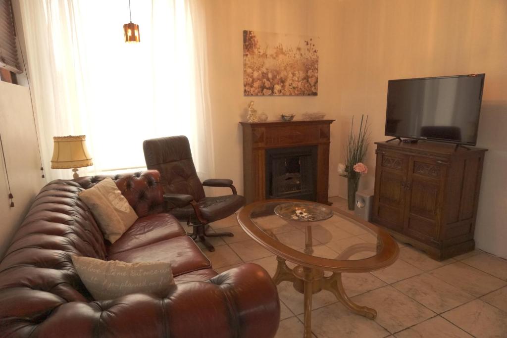 uma sala de estar com um sofá de couro e uma mesa em BSG Apartments em Selfoss