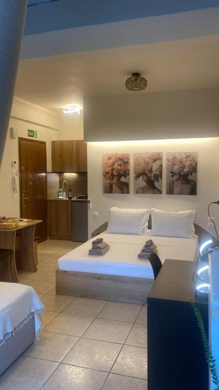a bedroom with a large white bed and a kitchen at Central studio D1 Volos in Volos