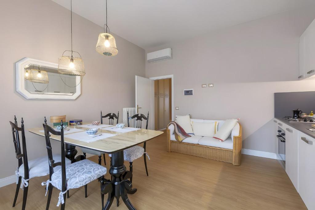 a kitchen and living room with a table and chairs at Il nido Emozioni charme e colori in Fiesole