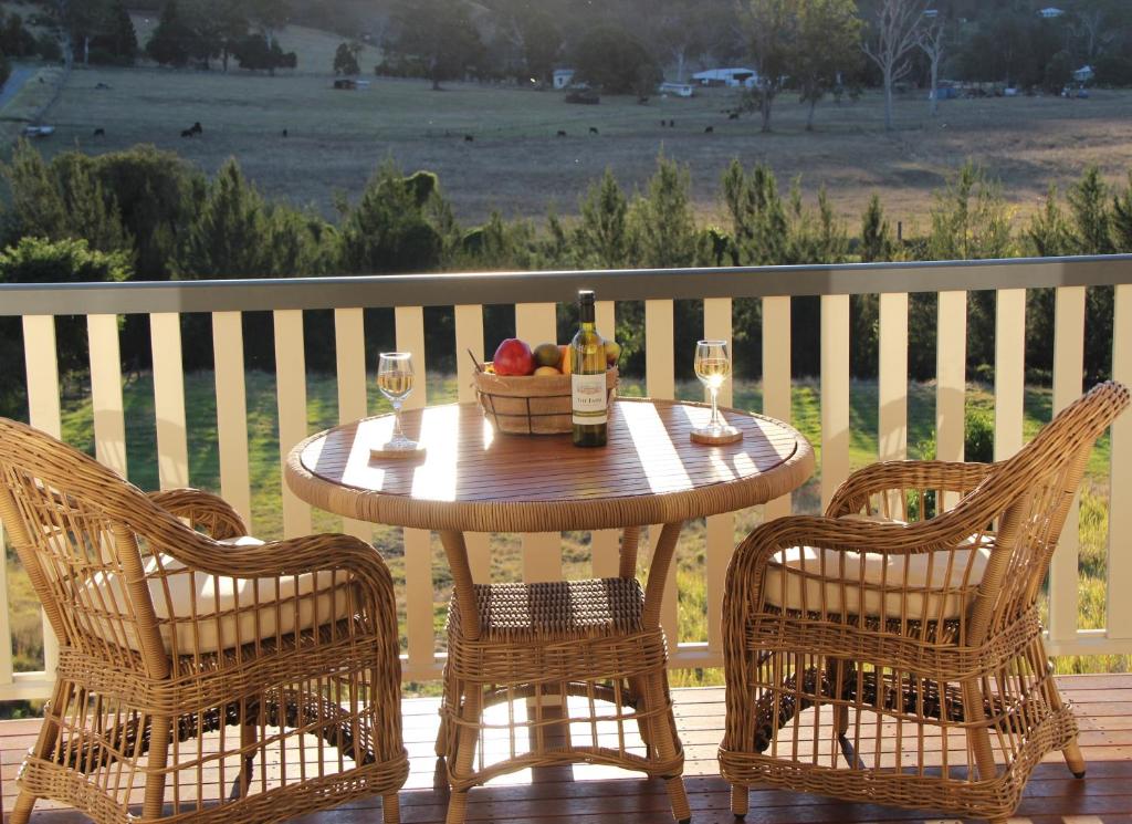 - une table en bois avec 2 chaises et un bol de fruits dans l'établissement Greenlee Cottages, à Canungra