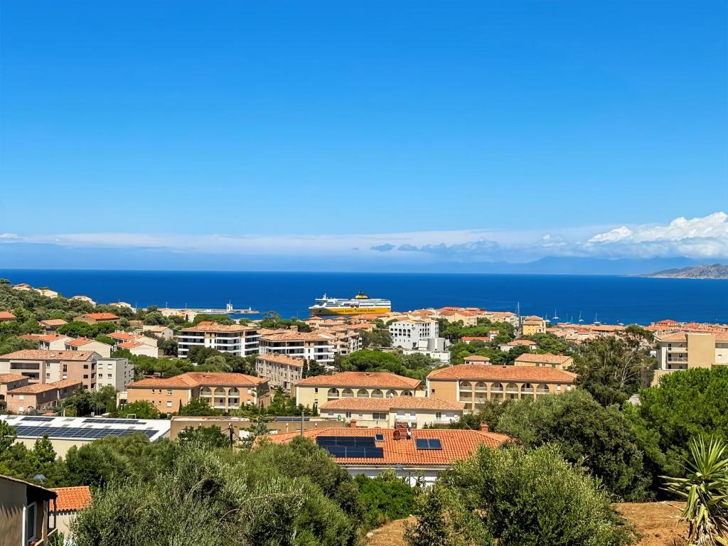 a view of a city with the ocean in the background at La Parenthèse Corse in LʼÎle-Rousse