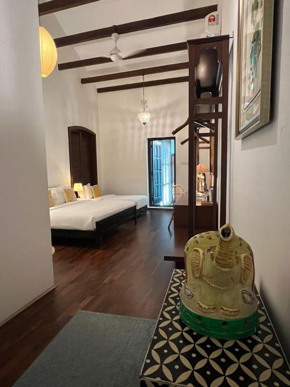 a living room with a room with a bed and a table at East Indies Mansion in George Town