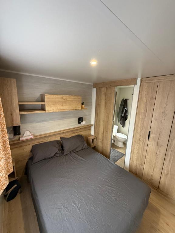1 dormitorio con 1 cama en una habitación pequeña en Mobilhome Cap'Oceha SIBLU-Les Viviers 4étoiles, en Lège-Cap-Ferret