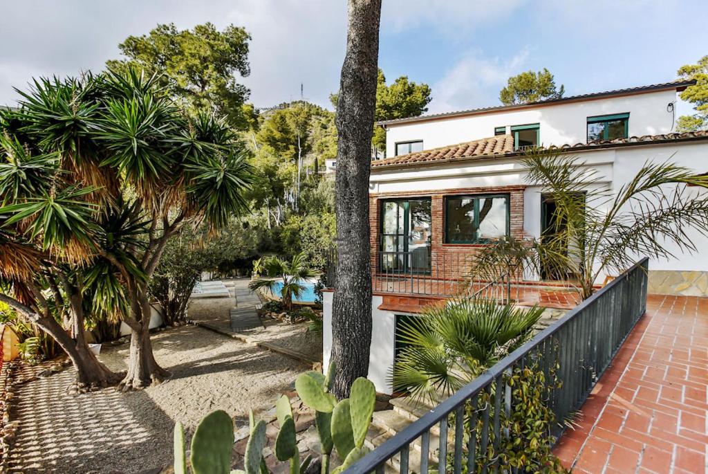 una casa con una valla y árboles delante de ella en Sun & Sand Sanctuary - 2km to beach and 20km BCN!, en Castelldefels
