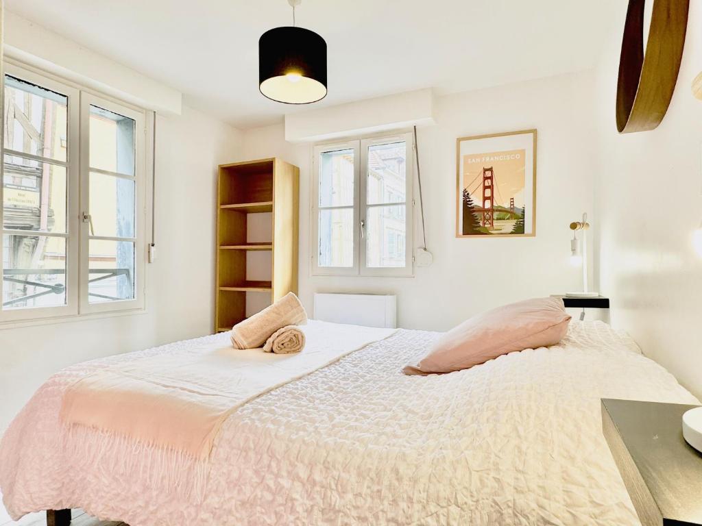 une chambre avec un lit et deux fenêtres dans l'établissement Logis de la Monnaie - Centre Historique - Parking offert, à Troyes