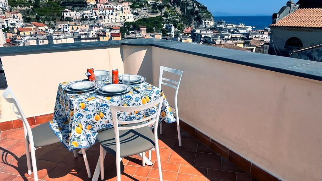 Una mesa y sillas en un balcón con vista. en Mansarda Oblique, en Maiori