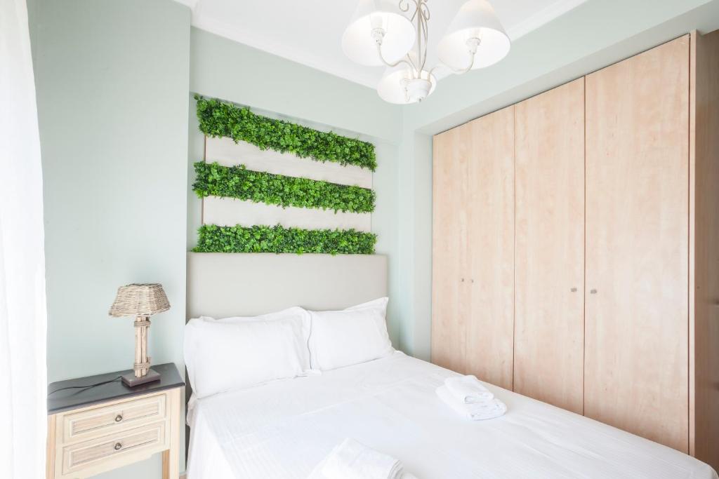 a bedroom with a white bed and a green wall at Afitos deluxe home in Afitos
