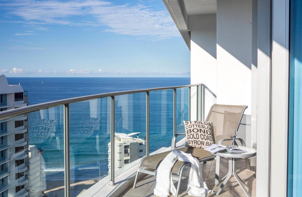 a balcony with a table and chairs and the ocean at Artique Surfers Paradise - Official in Gold Coast