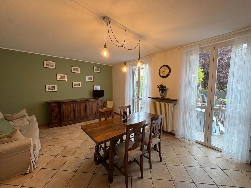 Una sala de estar con una mesa y sillas de madera. en Lake Como - Casa Mafy, en Bellano
