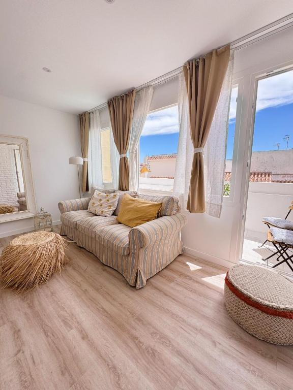 a living room with a couch and a large window at Sibs Sanlucar - casita playa - coqueto vistas in Sanlúcar de Barrameda
