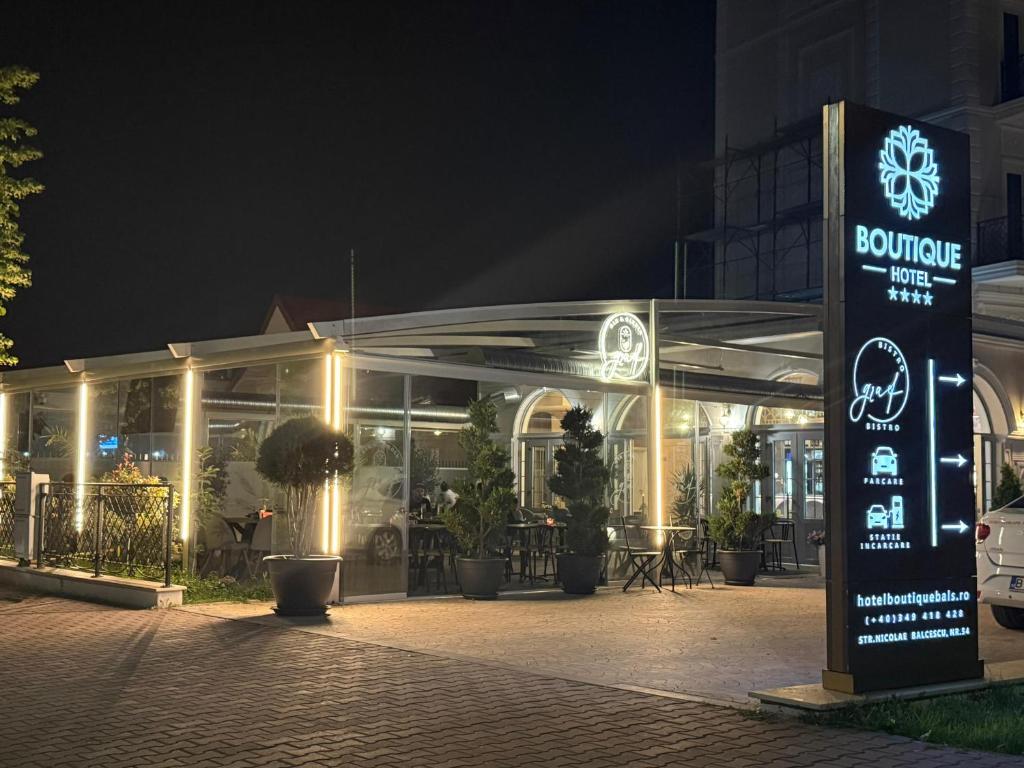 a building with a sign in front of it at night at Boutique Hotel Balș in Balş