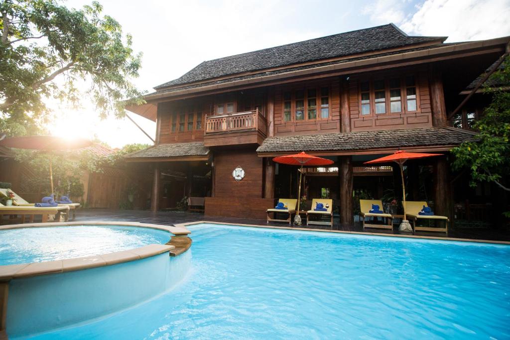 a house with a swimming pool in front of a building at Ruen Come In in Chiang Mai