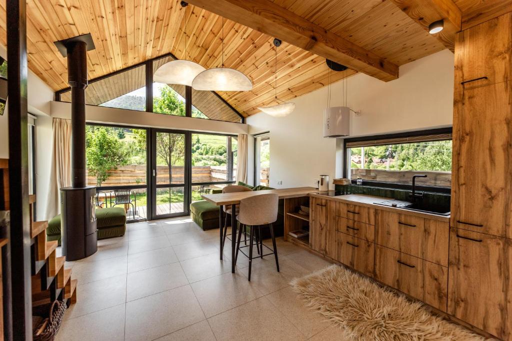 a kitchen with wooden ceilings and a table with chairs at UGRAD family котедж з чаном-джакузі in Slavske