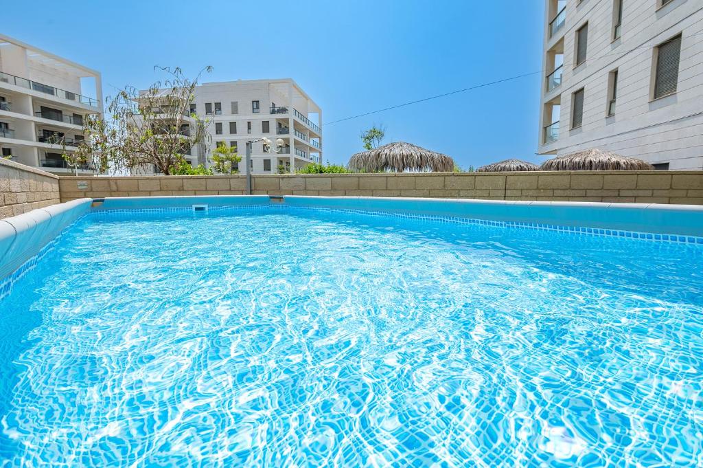 a large swimming pool on the side of a building at Achziv on the beach Apartment in Nahariyya