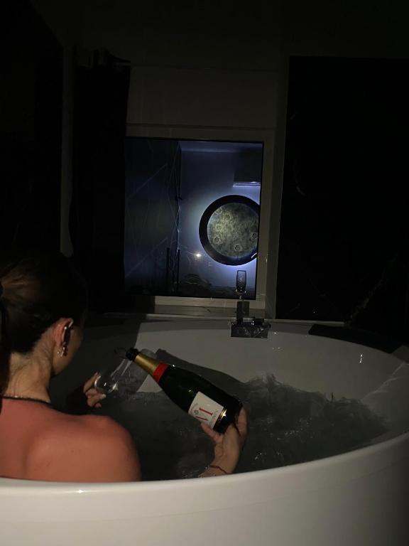 a woman sitting in a bath tub holding a bottle of wine at Syràkousai Prestige in Syracuse