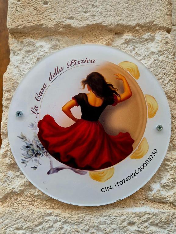 a plate with a woman in a red dress on it at La Casa della Pizzica in Ostuni