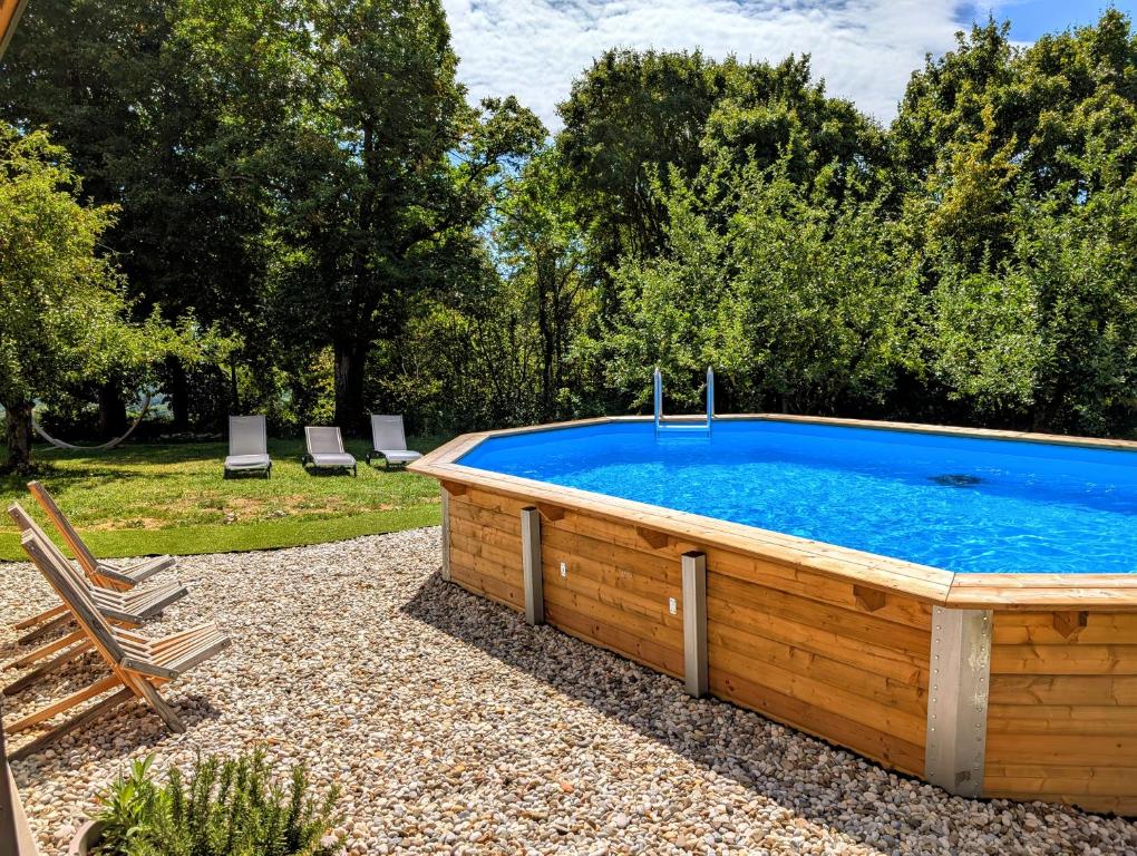 a large swimming pool in a yard with two chairs at Hiša na Ravnah in Pišece