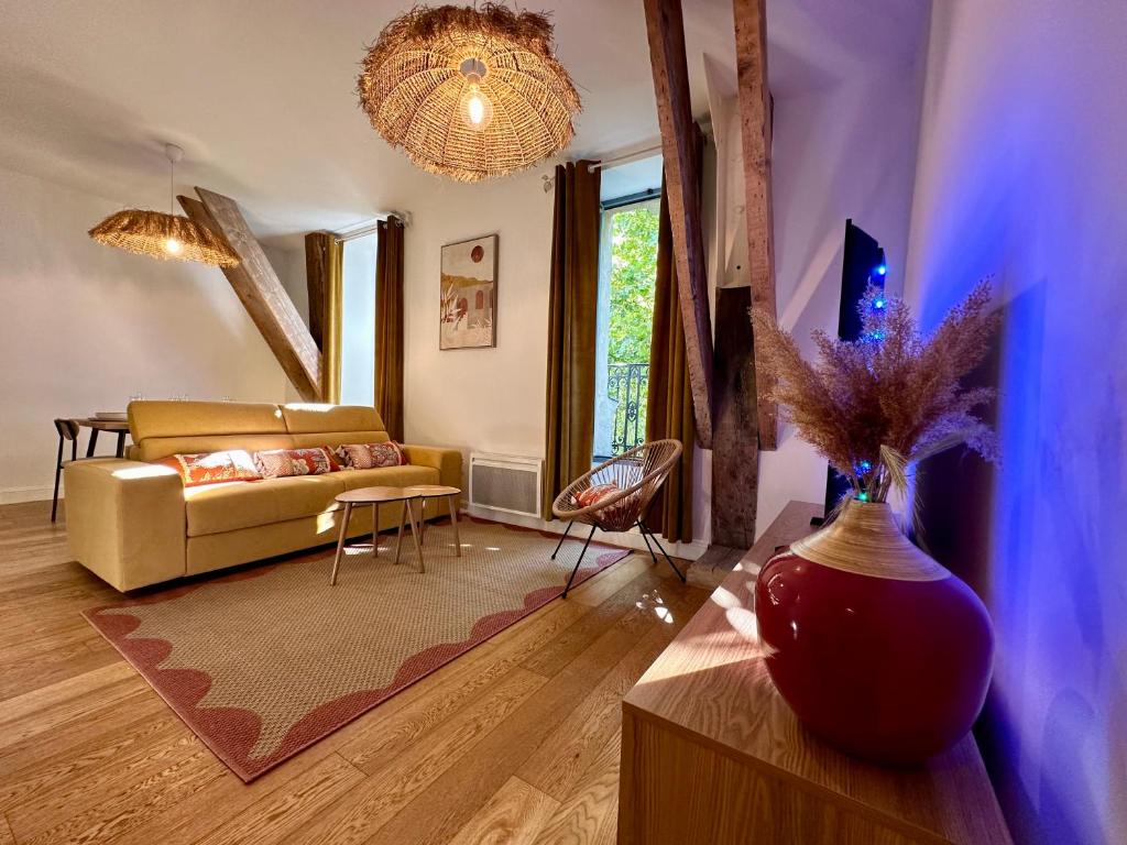 a living room with a couch and a vase at Appartement T2 Méditerranéen in Narbonne
