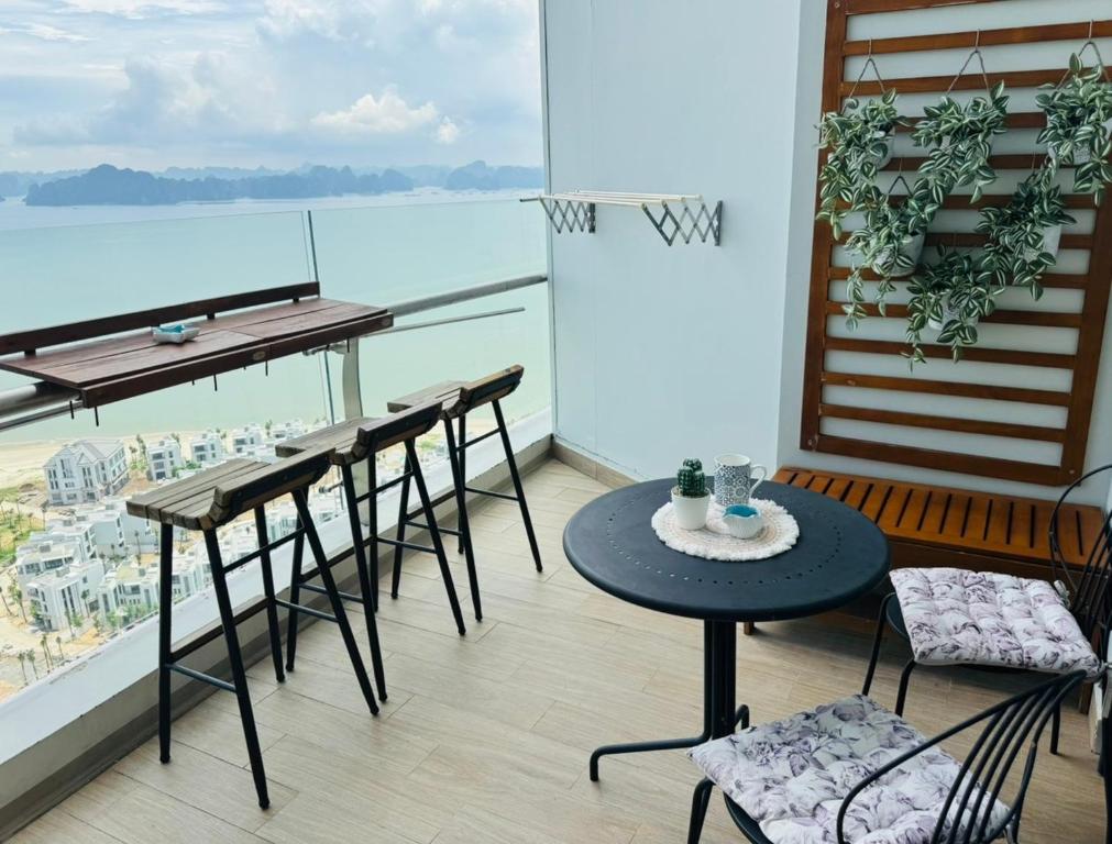 a balcony with tables and chairs and a view of the water at Paradis Homestay Marina Ha Long in Ha Long
